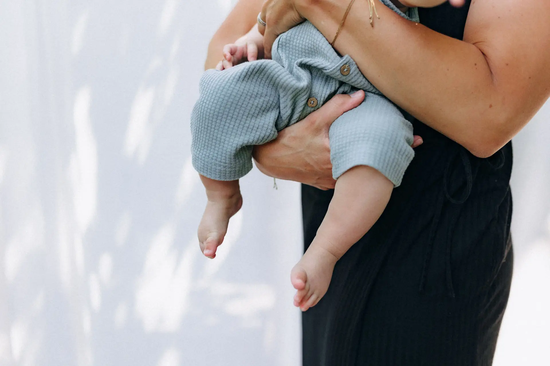 Mutter trägt ihr Baby im Arm